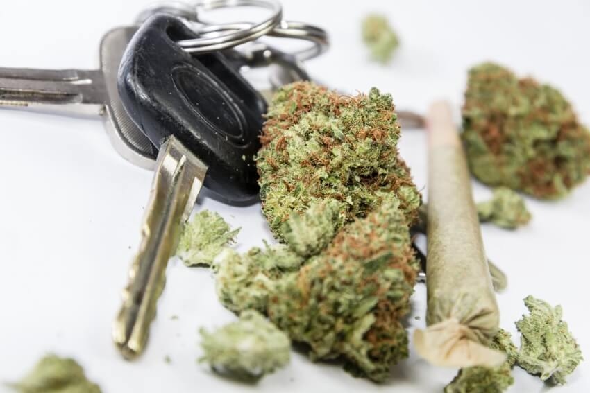 Autoschlüssel neben Cannabisblüten und einem Joint Autoschlüssel neben Cannabisblüten und einem Joint